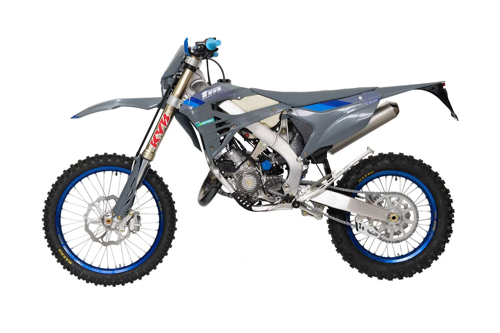 Zijaanzicht van een grijze crossmotor met blauwe accenten en noppenbanden op een witte achtergrond.